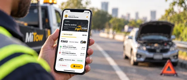 A new towing request in the MiTow Driver app, with a broken-down car behind